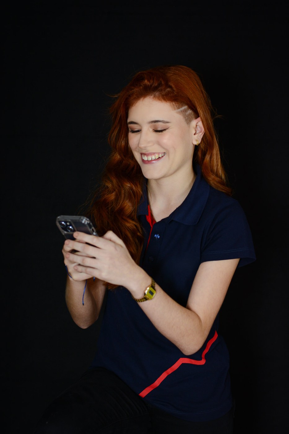 Ana Carolina sorrindo enquanto usa o celular
